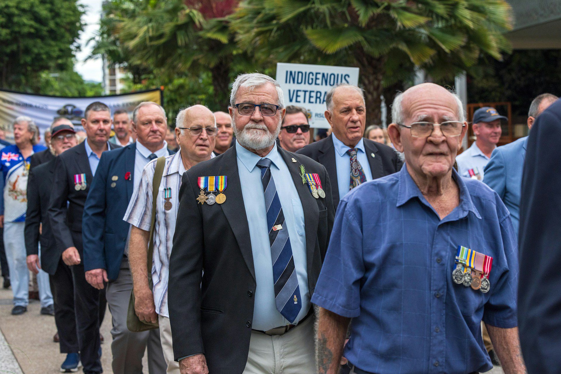 Group of elderly veterans marching with medals